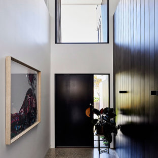 Großer Moderner Eingang mit Foyer, schwarzer Wandfarbe, Terrazzo-Boden, Drehtür, schwarzer Tür, grauem Boden, eingelassener Decke und vertäfelten Wänden in Geelong