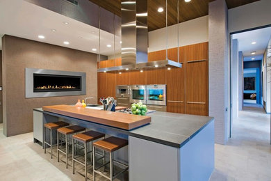 Inspiration for a large contemporary l-shaped cement tile floor eat-in kitchen remodel in Calgary with flat-panel cabinets, medium tone wood cabinets, stainless steel appliances, an island, a drop-in sink and wood countertops