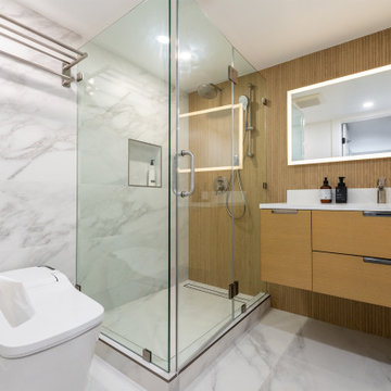 Large-format porcelain tile in soft earth tones now spans the floor and shower w