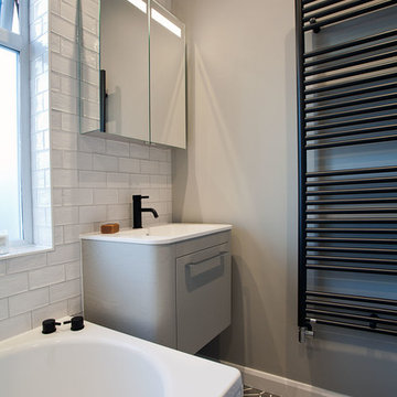 Family bathroom with matt black detailing and patterned tile floor – Hove