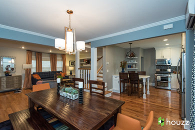Inspiration for a transitional medium tone wood floor and brown floor great room remodel in New York with blue walls and no fireplace