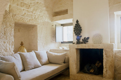 Modelo de sala de estar abierta contemporánea de tamaño medio con paredes blancas, suelo de piedra caliza, todas las chimeneas y marco de chimenea de piedra