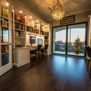 Idee per uno studio chic di medie dimensioni con libreria, parquet scuro, scrivania incassata e pareti grigie