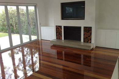 Großes Modernes Wohnzimmer mit weißer Wandfarbe, braunem Holzboden und braunem Boden in Geelong