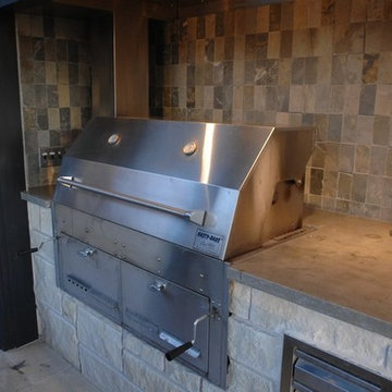 Outdoor Kitchen with Clean Concrete Countertops with Charcoal and Gas Grills