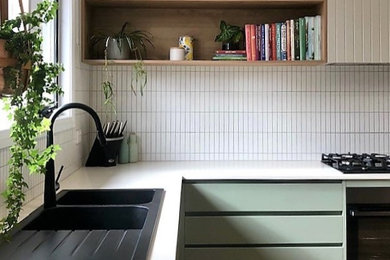 Contemporary u-shaped kitchen in Melbourne with white splashback, mosaic tile splashback and white benchtop.