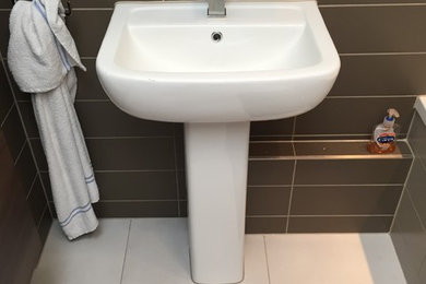 Photo of a medium sized modern ensuite bathroom in London with a built-in bath, brown walls, a pedestal sink and white floors.
