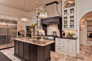 Large tuscan u-shaped travertine floor kitchen pantry photo in Austin with a farmhouse sink, glass-front cabinets, white cabinets, granite countertops, beige backsplash, porcelain backsplash, stainless steel appliances and an island