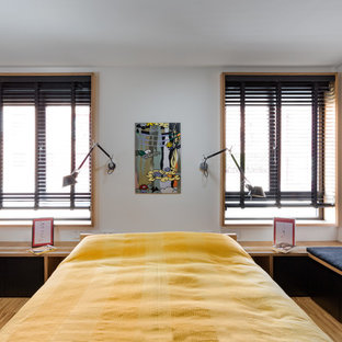 Ispirazione per una grande cameretta per bambini etnica con pareti bianche, pavimento in legno massello medio e pavimento marrone