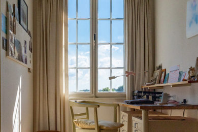 Uriges Arbeitszimmer mit Arbeitsplatz, weißer Wandfarbe, Teppichboden, freistehendem Schreibtisch, beigem Boden und Tapetenwänden in Köln