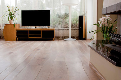 Example of a mid-sized minimalist enclosed light wood floor living room library design in Phoenix with white walls, a standard fireplace, a wood fireplace surround and a tv stand