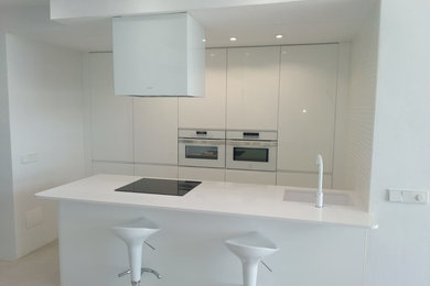 Diseño de cocina comedor minimalista pequeña con suelo beige y una isla