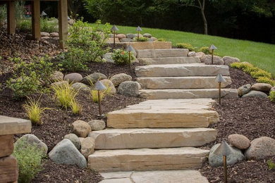 This is an example of a mid-sized transitional full sun backyard stone landscaping in Chicago.