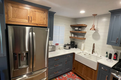 Eat-in kitchen - mid-sized farmhouse l-shaped light wood floor and brown floor eat-in kitchen idea in Milwaukee with a farmhouse sink, beaded inset cabinets, blue cabinets, quartzite countertops, white backsplash, ceramic backsplash, stainless steel appliances and white countertops