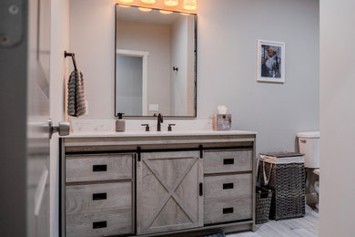 Small arts and crafts beige tile and ceramic tile single-sink, ceramic tile and gray floor alcove shower photo in Salt Lake City with flat-panel cabinets, gray cabinets, quartz countertops, white countertops, a built-in vanity, a two-piece toilet, gray walls, an undermount sink and a hinged shower door