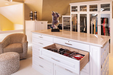 Large transitional women's carpeted and beige floor walk-in closet photo in Tampa with glass-front cabinets and white cabinets