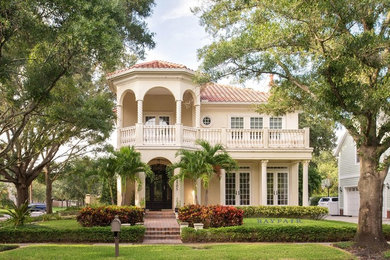 This is an example of a large mediterranean two-storey stucco beige house exterior in Tampa with a hip roof and a tile roof.