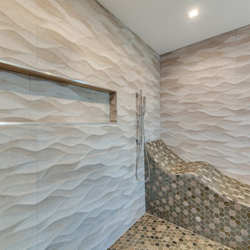 Wave Tile Shower with Pebble Mosaic Floor and Stone Bench
