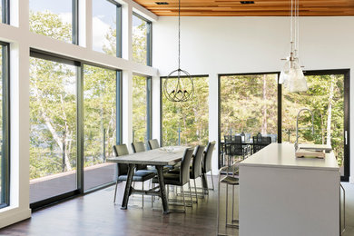 This is an example of a contemporary dining room in Montreal with white walls, dark hardwood floors and no fireplace.