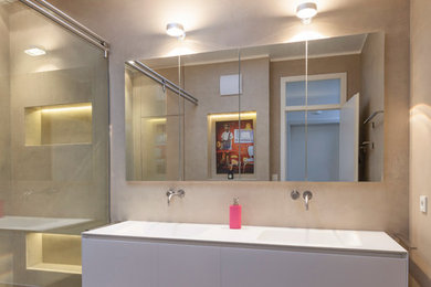 Mittelgroßes Modernes Duschbad mit flächenbündigen Schrankfronten, weißen Schränken, bodengleicher Dusche, beiger Wandfarbe, integriertem Waschbecken, grauem Boden und Schiebetür-Duschabtrennung in Köln