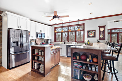 Example of a mid-sized mountain style u-shaped light wood floor eat-in kitchen design in St Louis with a double-bowl sink, flat-panel cabinets, medium tone wood cabinets, quartz countertops, multicolored backsplash, slate backsplash, stainless steel appliances, an island and beige countertops