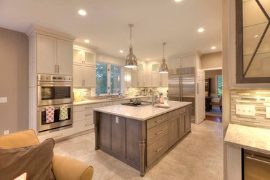 Inspiration for a timeless kitchen remodel in Other with white cabinets, stainless steel appliances and an island