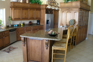 Eat-in kitchen - mid-sized eclectic u-shaped ceramic tile and beige floor eat-in kitchen idea in Miami with an undermount sink, raised-panel cabinets, medium tone wood cabinets, granite countertops, beige backsplash, stone slab backsplash, stainless steel appliances and an island