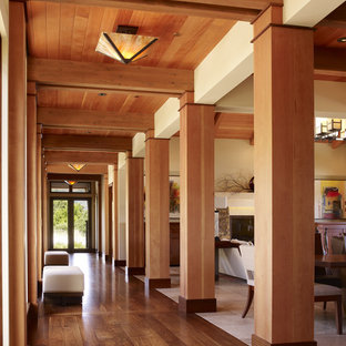 Foto på en stor funkis hall, med mellanmörkt trägolv, beige väggar och brunt golv