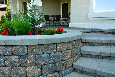 Photo of a mid-sized transitional partial sun backyard brick retaining wall landscape in Calgary for spring.
