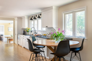 Example of a mid-sized country galley eat-in kitchen design in Boston with shaker cabinets, white cabinets, granite countertops, no island and black countertops