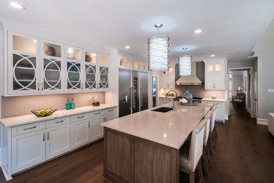 Photo of a large transitional l-shaped eat-in kitchen in Dallas with with island, an undermount sink, shaker cabinets, white cabinets, marble benchtops, white splashback, glass tile splashback, stainless steel appliances, dark hardwood floors and brown floor.