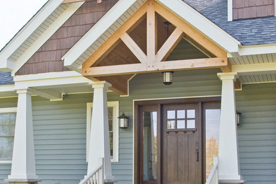 Example of an arts and crafts concrete floor and gray floor entryway design in Cleveland with green walls and a dark wood front door