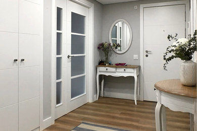 Imagen de distribuidor clásico renovado grande con paredes grises, suelo laminado, puerta doble, puerta blanca y suelo gris