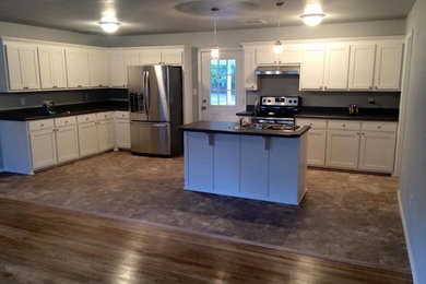 Example of a large transitional u-shaped open concept kitchen design in Other with a drop-in sink, shaker cabinets, white cabinets, stainless steel appliances and an island