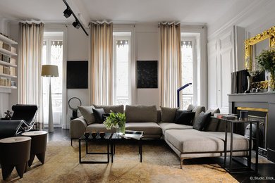 Réalisation d'un grand salon design ouvert avec un mur beige, parquet foncé, une cheminée standard, un manteau de cheminée en pierre, un sol marron, une salle de réception et un téléviseur encastré.