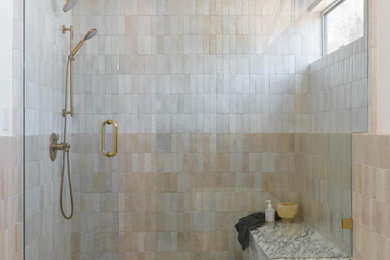 Example of a mid-sized mid-century modern master beige tile and ceramic tile concrete floor, white floor, double-sink and vaulted ceiling bathroom design in Orange County with flat-panel cabinets, light wood cabinets, a one-piece toilet, white walls, an undermount sink, marble countertops, a hinged shower door, multicolored countertops and a built-in vanity