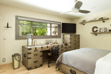 Photo of a large industrial bedroom in Los Angeles with grey walls, light hardwood floors and beige floor.