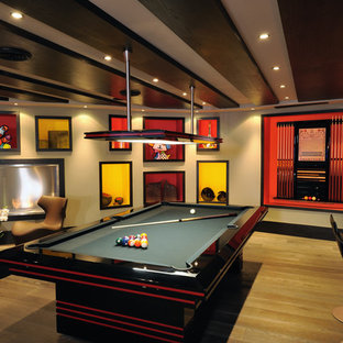 パリのコンテンポラリースタイルのおしゃれな地下室 (ベージュの壁、淡色無垢フローリング、横長型暖炉、金属の暖炉まわり) の写真