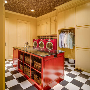 Foto de cuarto de lavado clásico renovado, grande, con armarios estilo shaker, puertas de armario amarillas, encimera de granito, paredes amarillas, suelo de baldosas de cerámica, lavadora y secadora juntas y fregadero sobremueble