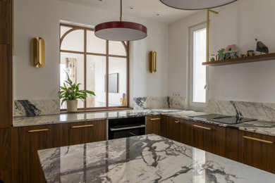 Cette photo montre une grande cuisine ouverte encastrable, haussmannienne et blanche et bois chic en U avec un évier encastré, un placard à porte affleurante, des portes de placard marrons, plan de travail en marbre, une crédence rouge, une crédence en marbre, parquet clair, îlot, un sol marron et un plan de travail rouge.