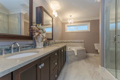 Inspiration for a mid-sized timeless master beige tile ceramic tile bathroom remodel in Vancouver with recessed-panel cabinets, dark wood cabinets, a one-piece toilet, beige walls and a drop-in sink