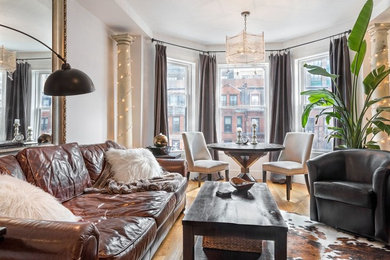 Example of a small trendy light wood floor family room design in Boston with white walls, a standard fireplace and a wall-mounted tv