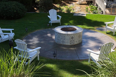 Imagen de patio clásico de tamaño medio sin cubierta en patio trasero con brasero y losas de hormigón