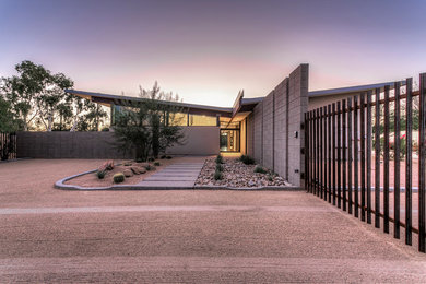 Photo of a modern entryway in Phoenix with concrete floors, a pivot front door, a glass front door and grey floor.