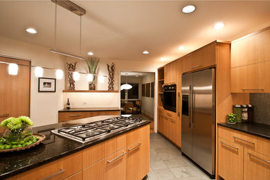 Inspiration for a contemporary open concept kitchen remodel in Portland with an undermount sink, flat-panel cabinets, light wood cabinets, granite countertops, green backsplash and stainless steel appliances
