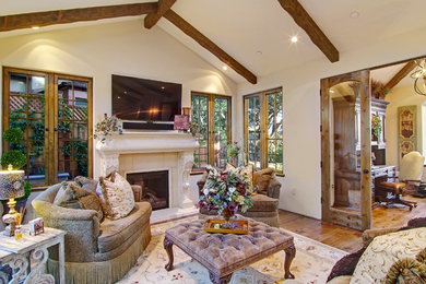 Living room - mid-sized traditional open concept medium tone wood floor living room idea in Other with beige walls, a standard fireplace, a stone fireplace and a wall-mounted tv