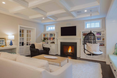 Example of a transitional dark wood floor and brown floor family room design in DC Metro with beige walls, a standard fireplace, a metal fireplace and a wall-mounted tv