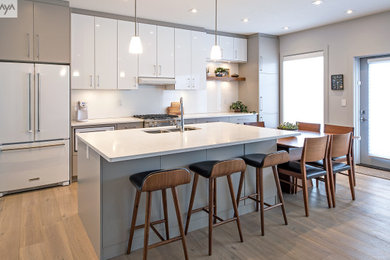 Inspiration for a mid-sized modern single-wall light wood floor and beige floor open concept kitchen remodel in Other with a double-bowl sink, flat-panel cabinets, white cabinets, quartz countertops, white backsplash, quartz backsplash, white appliances, an island and white countertops