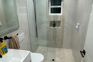 Inspiration for a small craftsman white tile and porcelain tile porcelain tile, beige floor and single-sink bathroom remodel in San Francisco with white cabinets, a wall-mount toilet, white walls, a wall-mount sink, solid surface countertops, white countertops, a niche and a floating vanity