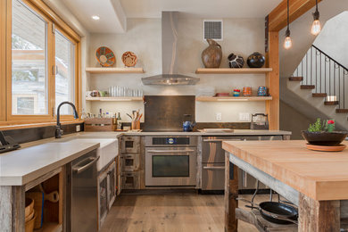 Inspiration for a large mediterranean l-shaped kitchen in Salt Lake City with a farmhouse sink, medium wood cabinets, stainless steel appliances, medium hardwood floors, with island, glass-front cabinets, wood benchtops and brown splashback.